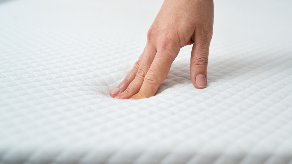 person testing mattress firmness